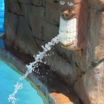 Tiki head squirts water at waterpark pool