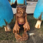 Troll statue with big hands and feet at mini golf course