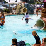 Young children playfully playing in waterpark pool