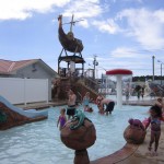 Families play under an adventure shower at waterpark