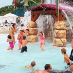 Young girls play under waterfall at waterpark