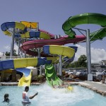 Son and father come out of waterslide making big splash