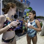 Girls eat icecream as boy orders icecream at waterpark