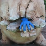 Blue hand coming out of cracked stone egg