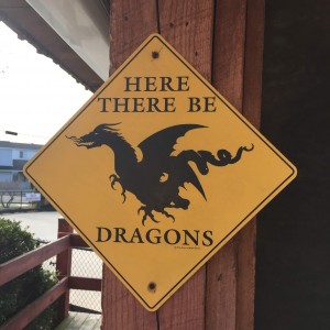 Yellow sign warning of dragons at mini golf course
