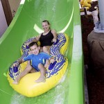 Mother and son slide down waterpark waterslide