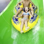 Brother and sister splash down waterpark waterslide